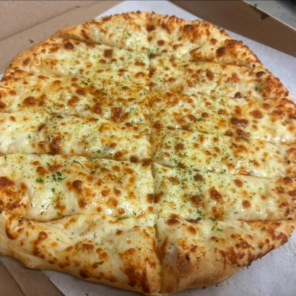 A freshly baked, cheesy garlic bread pizza from 7th Street Pizza, cut into strips.