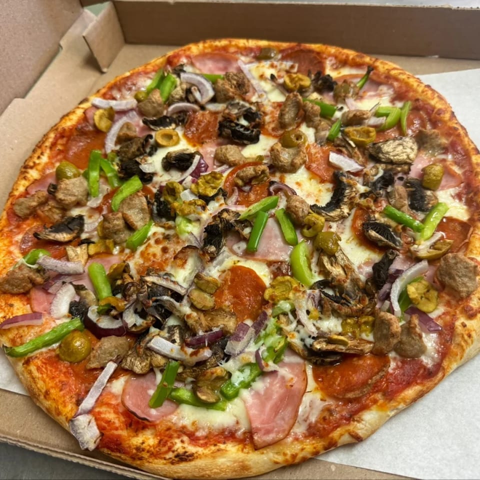 A 7th Street Pizza with pepperoni, ham, sausage, green peppers, onions, mushrooms, and olives.